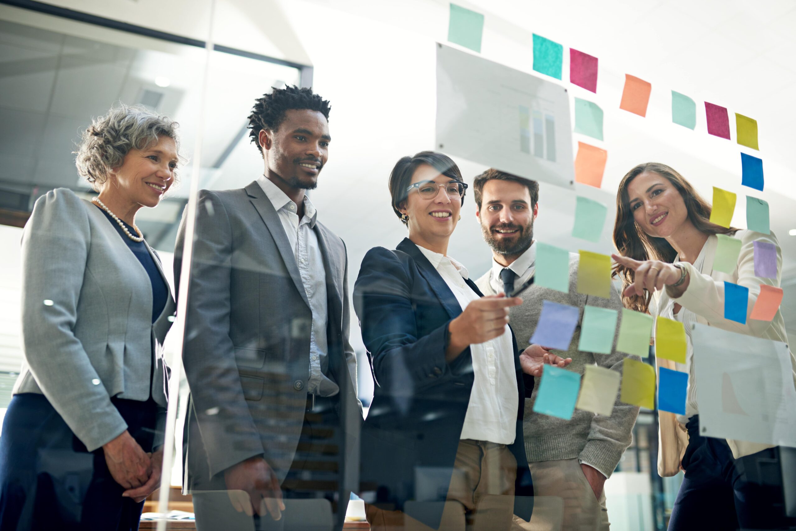 Shot of a group of businesspeople brainstorming on a glass wall in an office